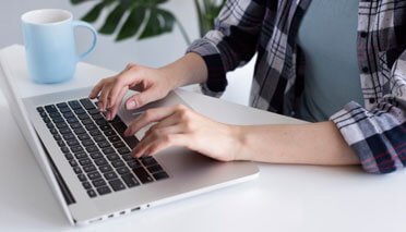 student typing with a laptop